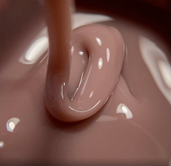 Thick nude pink builder gel for nails, closeup view of glossy manicure product texture