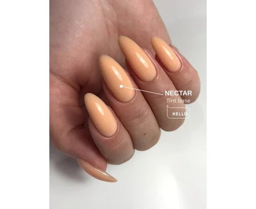 Hand with long almond-shaped nails featuring glossy peach gel polish tint base