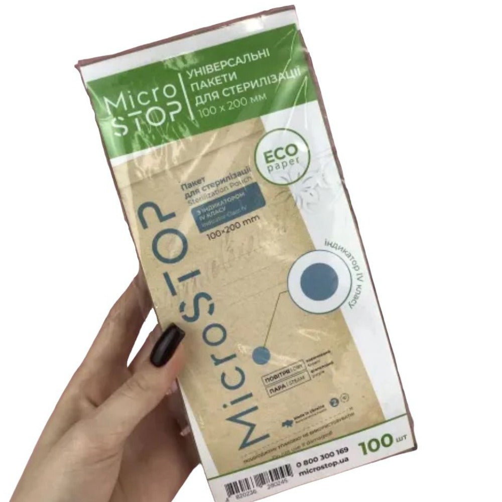Hand holding MicroStop sterilization pouches 100x200mm, eco paper, manicure tool hygiene