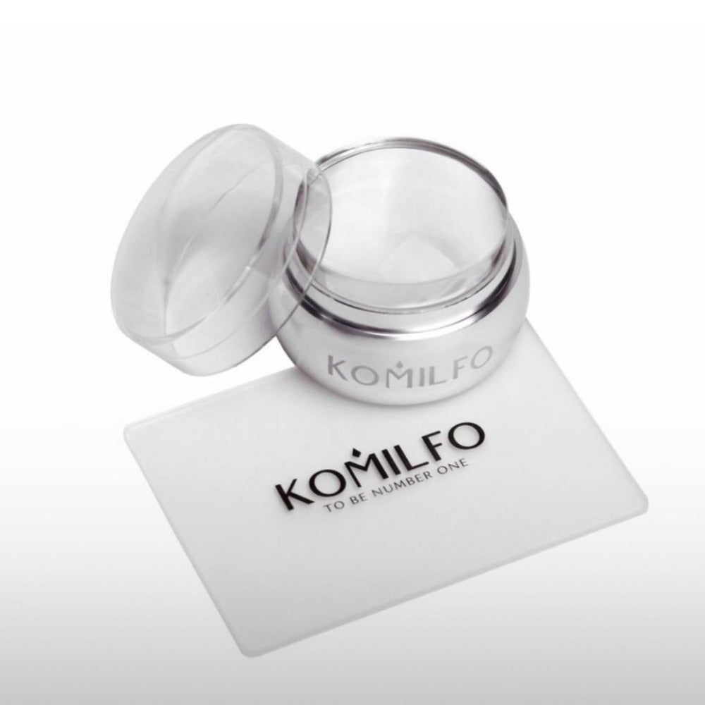Open silver Komilfo nail gel jar with clear lid and branded plastic card on white background