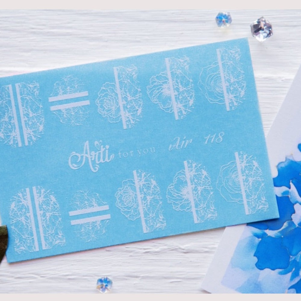 Blue nail art sticker sheet with white floral designs, manicure accessory on white background