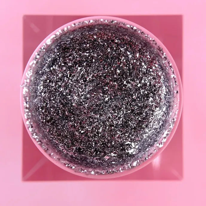 Open jar of platinum silver glitter UV gel for nails on a pink background