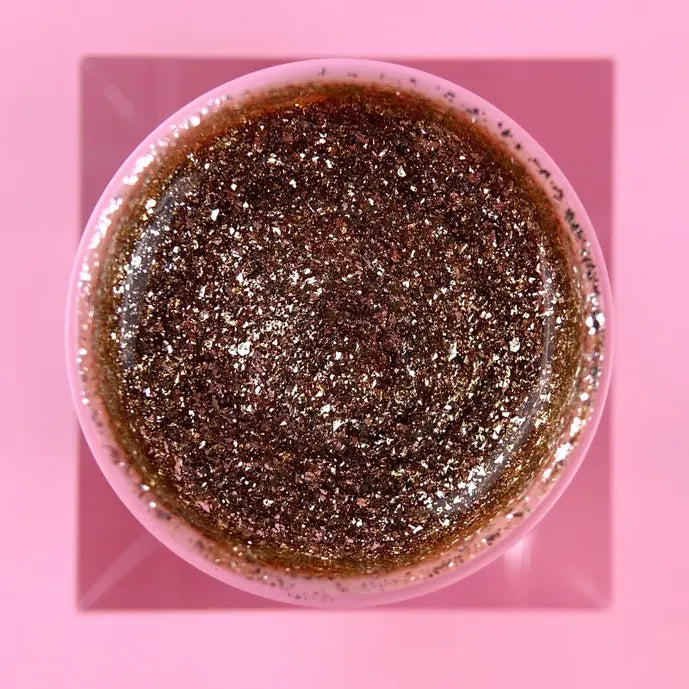 Open jar of sparkling platinum UV nail gel with glitter on a pink background