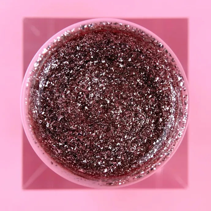 Open jar of pink glitter UV gel for nails on a pink background