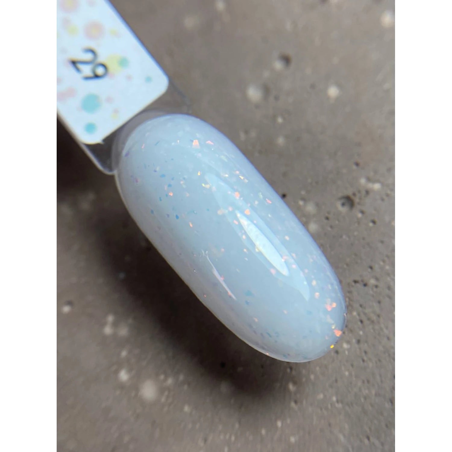 Swatch of pale blue UV gel nail polish with subtle glitter on a sample nail tip