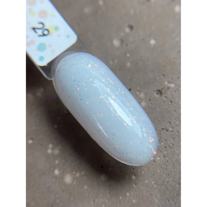 Swatch of pale blue UV gel nail polish with subtle glitter on a sample nail tip