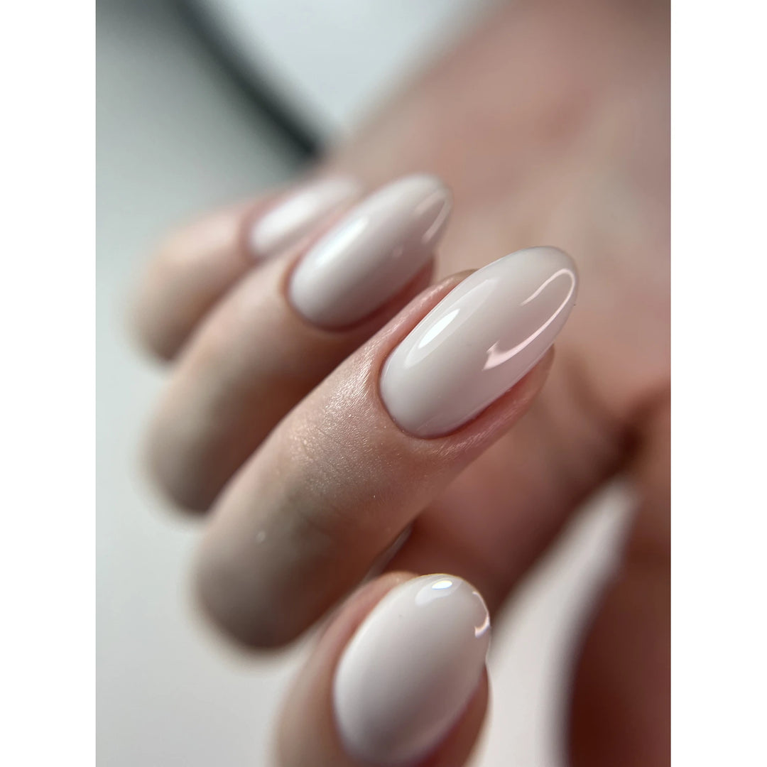 Close-up of hand with glossy nude gel manicure, almond-shaped nails