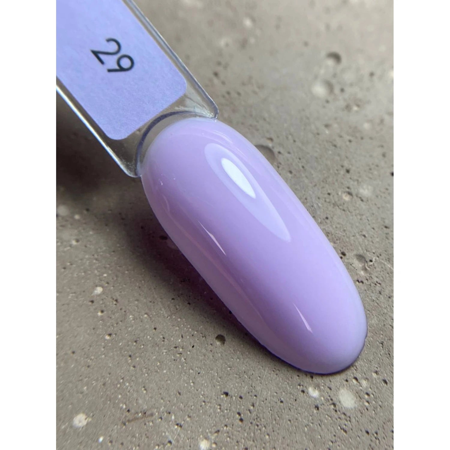 Swatch of glossy pastel lavender gel nail polish on sample stick, manicure accessory