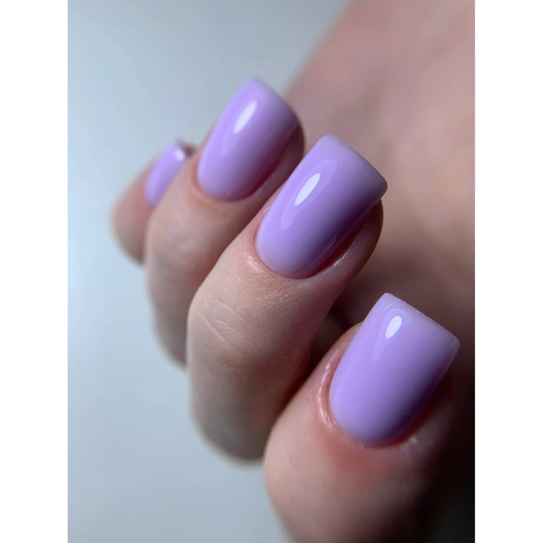 Close-up of a hand with short, glossy pastel purple gel polished nails