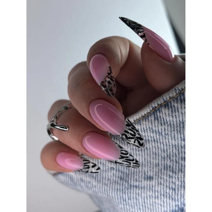 Long almond-shaped nails with pink ombre and black abstract tips, manicure design