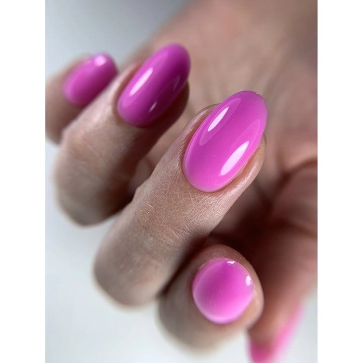 Hand with glossy pink gel manicure, oval-shaped nails, professional nail polish