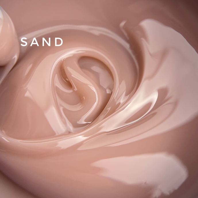 Close-up of swirling nude sand-colored nail gel polish, smooth creamy texture