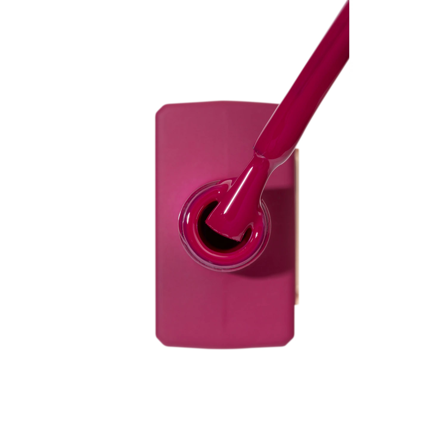 Deep pink gel nail polish bottle with brush, manicure product close-up