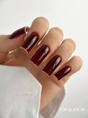 Hand with long square burgundy gel nails, glossy finish, professional manicure