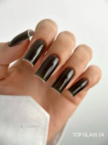 Hand with long square gel nails in glossy dark translucent color, manicure close-up