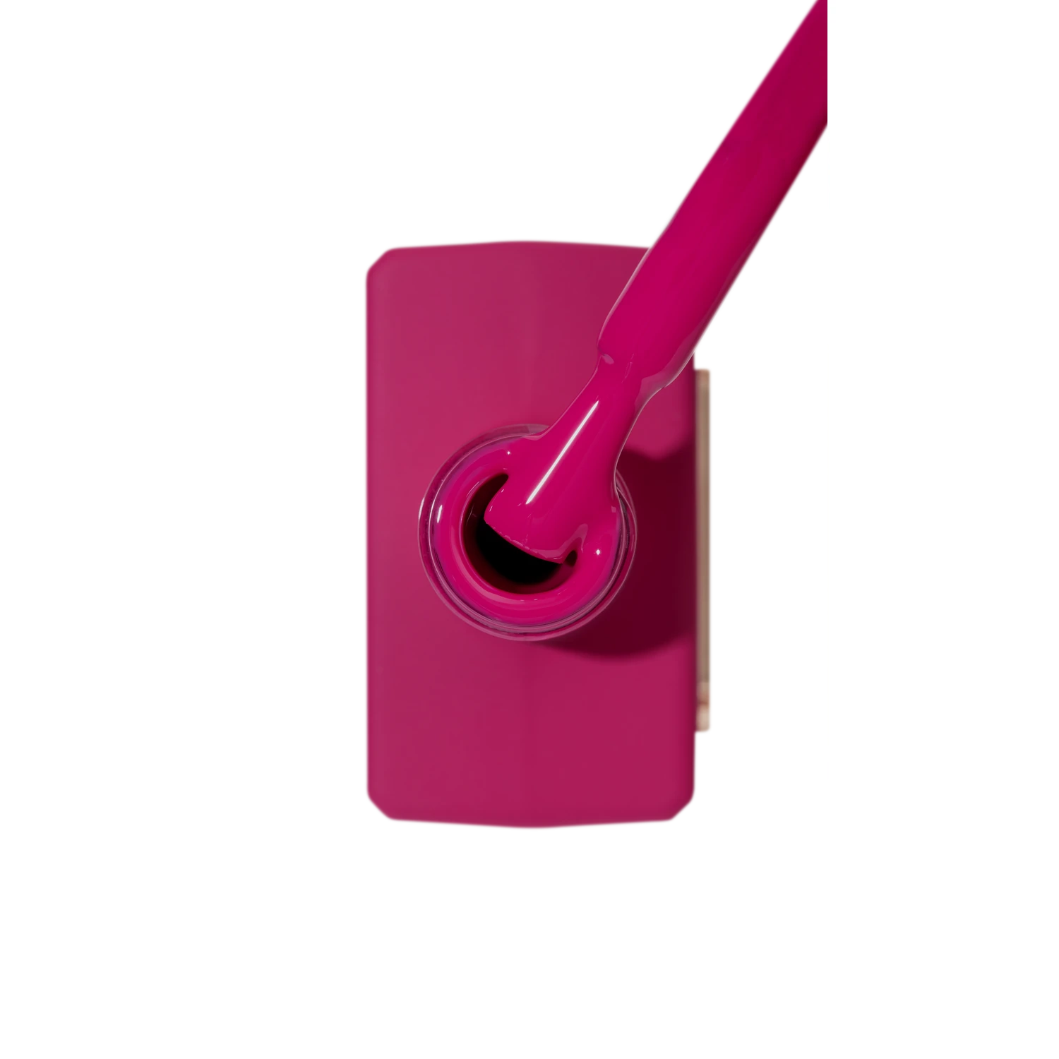 Vibrant magenta nail polish bottle with brush, professional manicure gel color