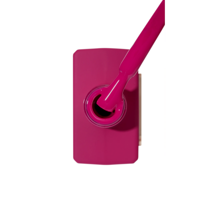Vibrant magenta nail polish bottle with brush, professional manicure gel color