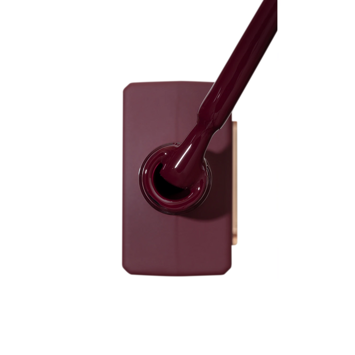 Burgundy UV gel nail polish bottle with applicator brush, professional nail product