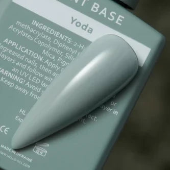 Sample nail tip painted with pastel sage green gel polish on a product bottle labeled Yoda