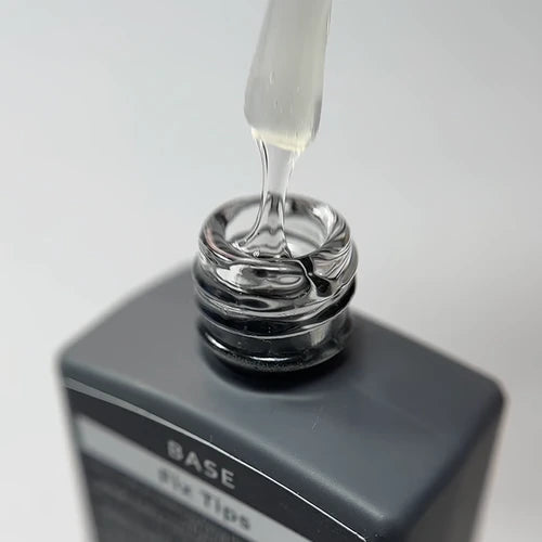 Close-up of a base gel nail polish bottle with brush applicator for manicure