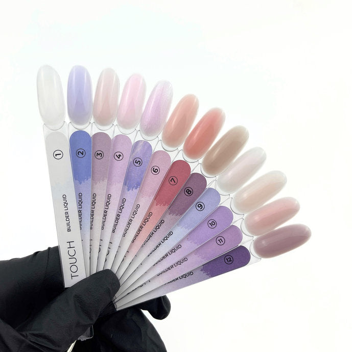 Hand in black glove holding fan of builder liquid nail gel color samples in pastel shades