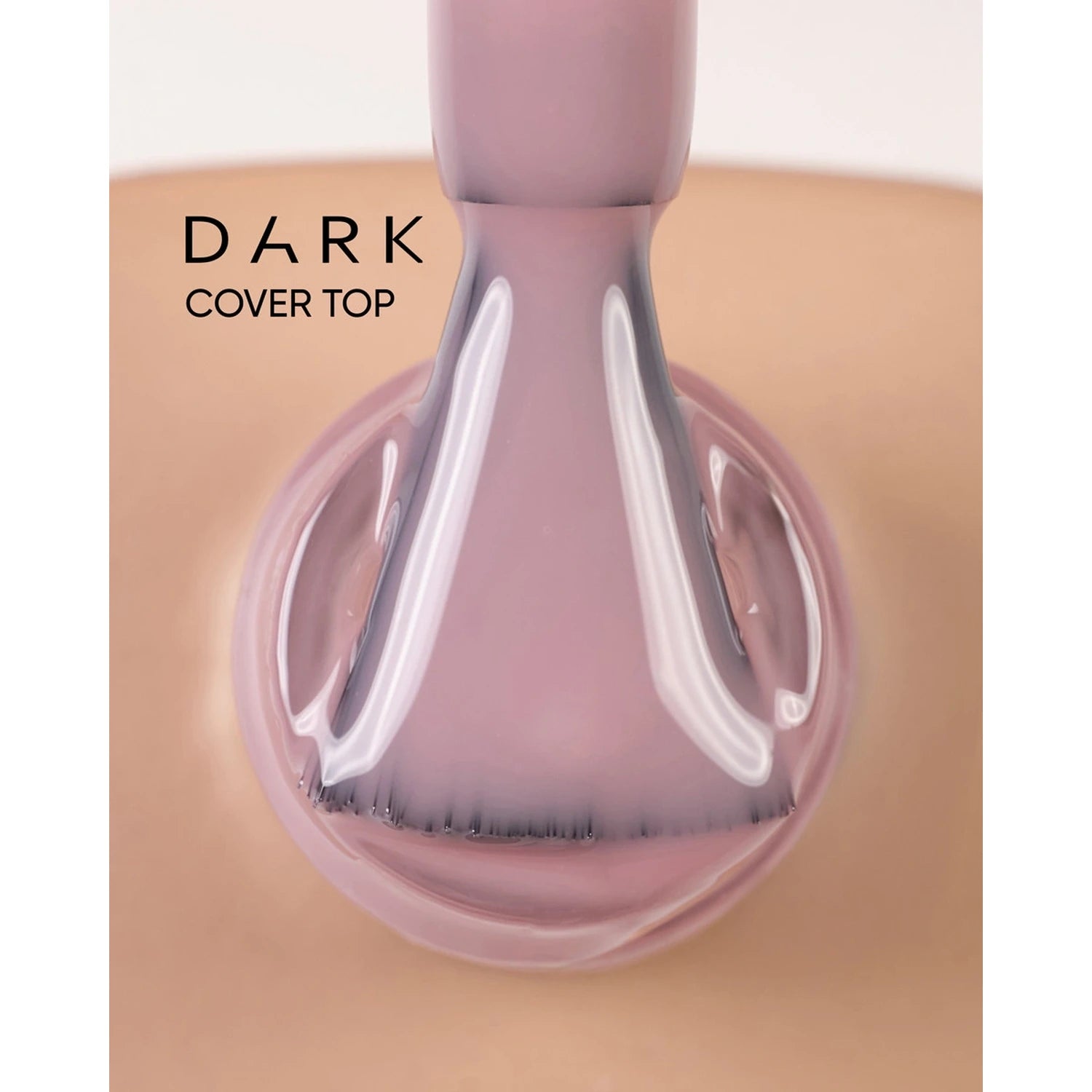 Close-up of a nail brush applying dark cover top UV gel polish on a fingernail