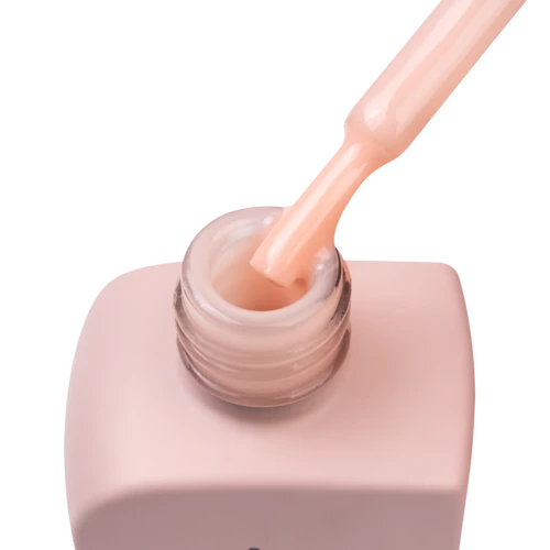 Pink nail polish bottle with a brush dipping into the polish on a white background