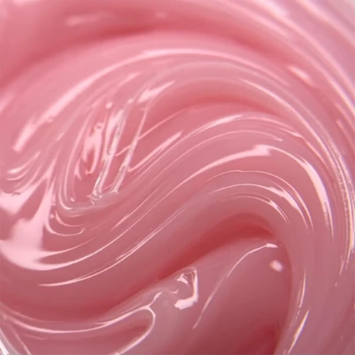 Close-up of pink UV poly gel with glossy texture for manicure and nail extension.