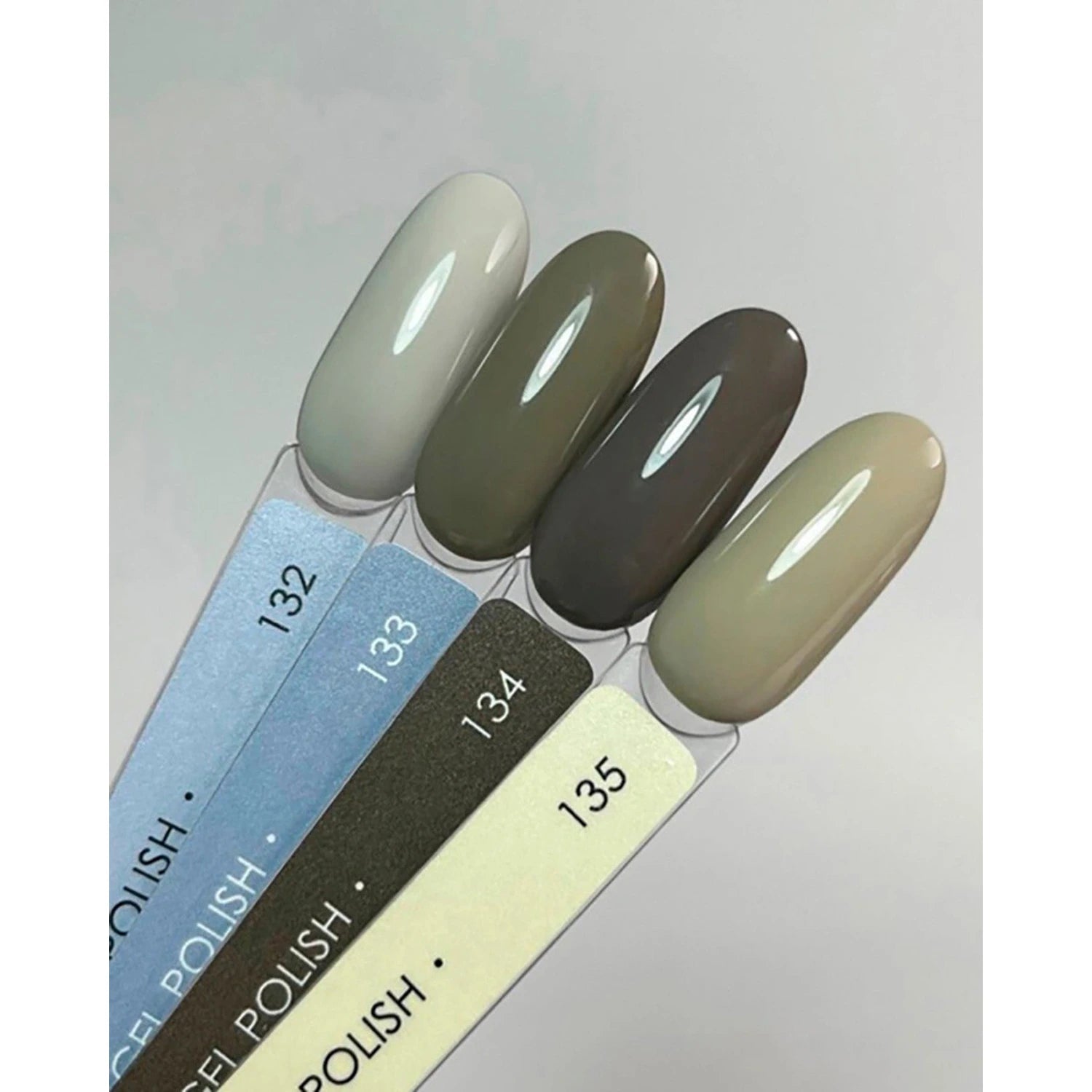 Gel polish nail color swatches in neutral and gray shades, numbered 132 to 135.