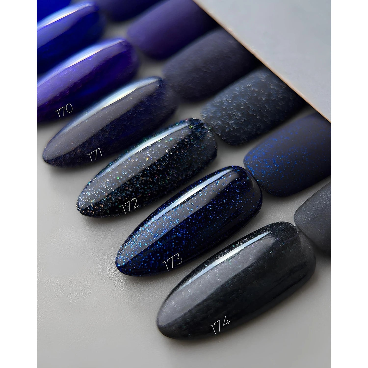 Assorted blue and black glitter gel nail polish samples, labeled 170 to 174, for manicure.