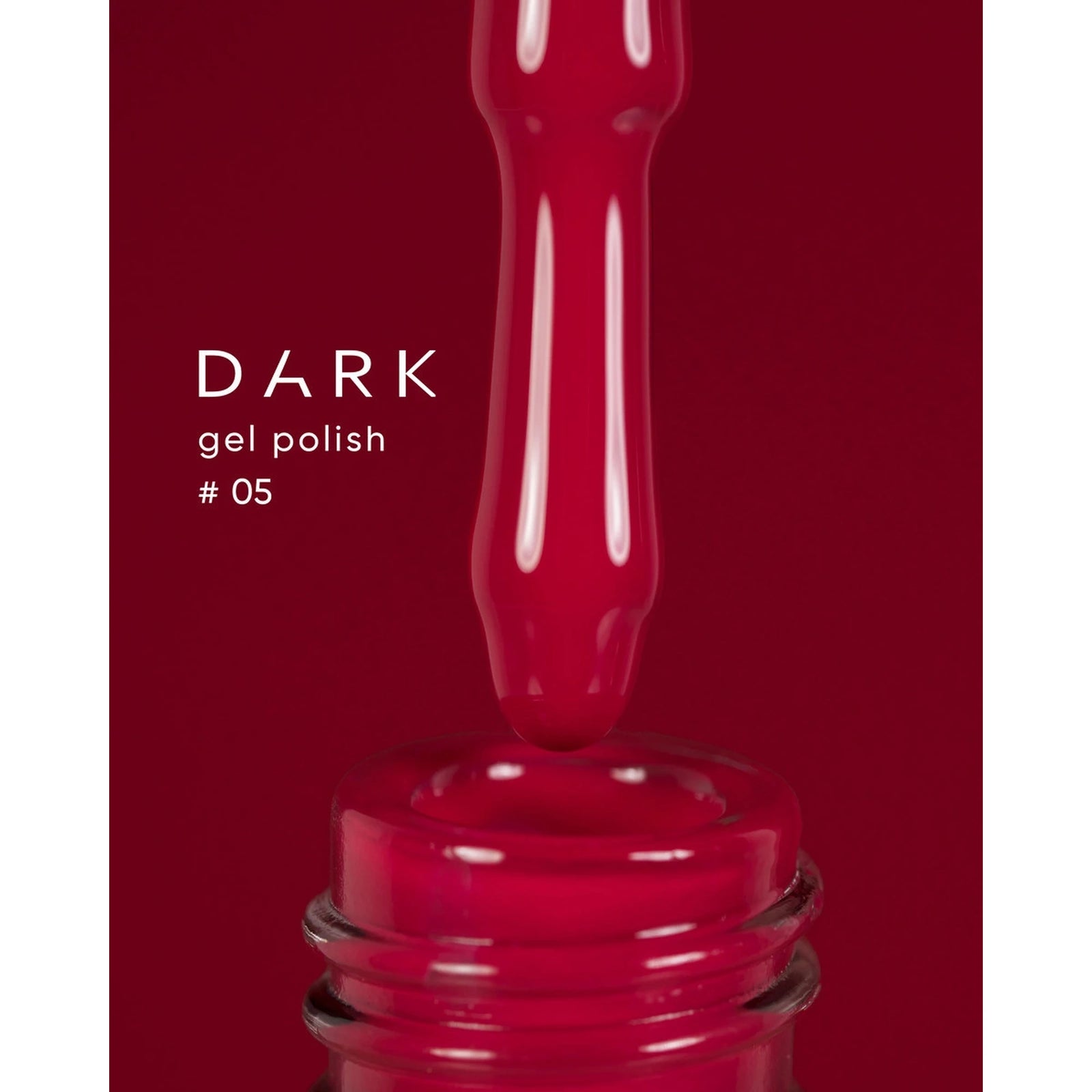 Dark gel polish #05, deep red UV gel dripping from brush into bottle, close-up.