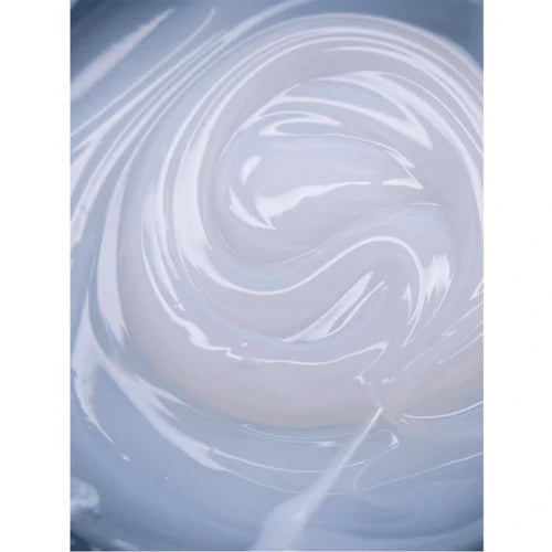 Close-up of swirling UV gel polish texture in soft white and gray shades for manicure