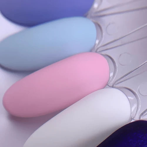 Matte pastel nail polish swatches in blue, pink, and white on display sticks