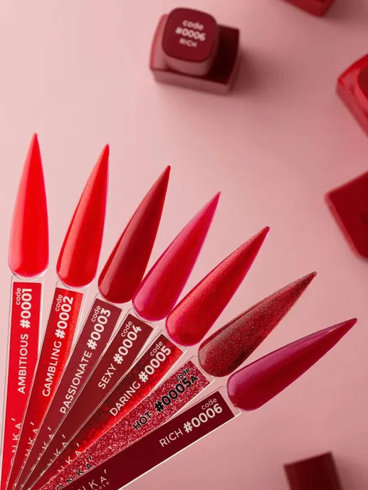 Red and pink gel nail polish samples with code labels on a pink background.