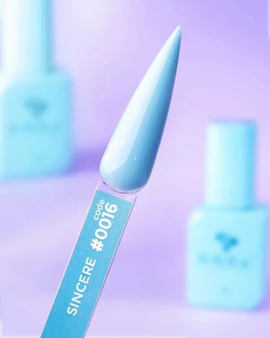 Light blue gel nail polish swatch labeled code #0016, with bottles in soft focus background