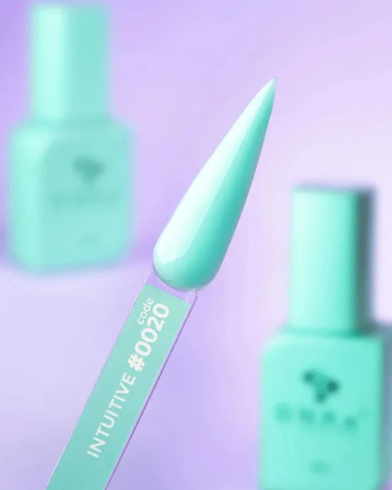 Aqua mint nail polish swatch stick, labeled code #0020, with matching gel bottles in background.
