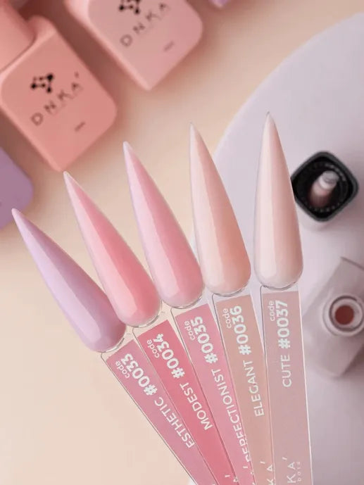 five pastel gel nail polish color samples on display sticks, soft pink and nude shades