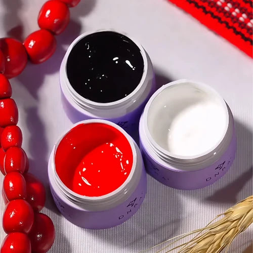 Open gel nail polish jars in black, white, and red for manicures and nail art