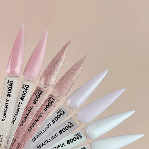 Fan of nail color swatches in soft pink, nude, and white shades with shimmer, labeled for manicure.