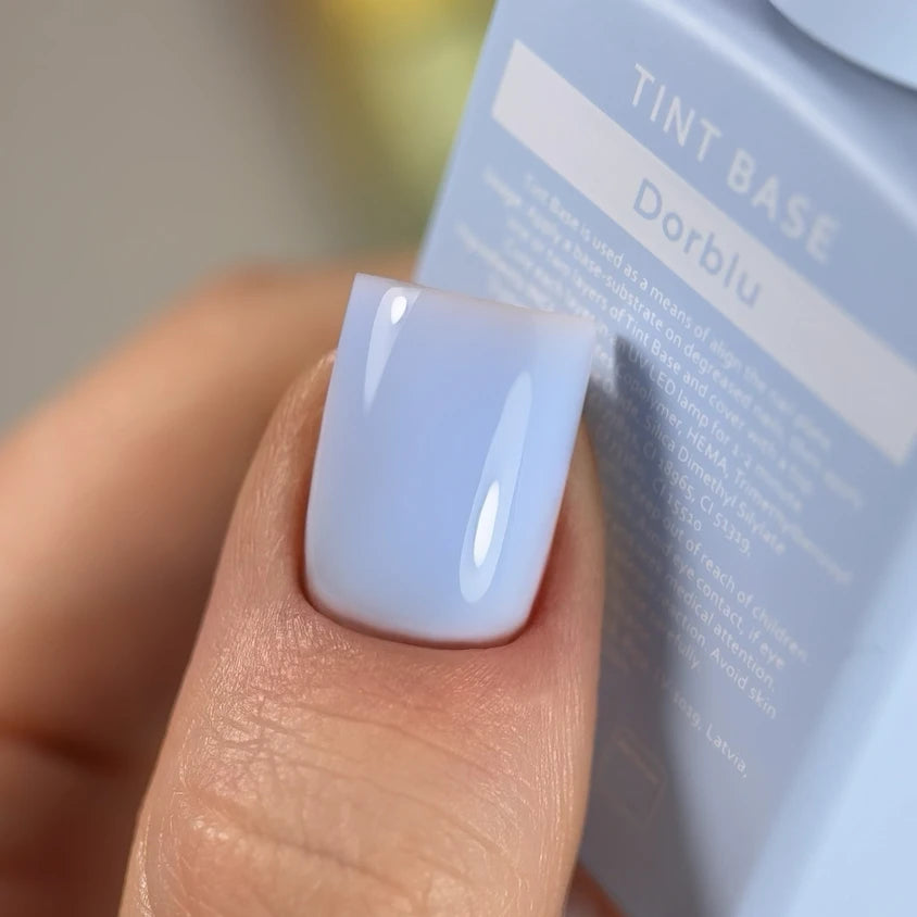 Close-up of fingernail with glossy pastel blue UV gel polish manicure