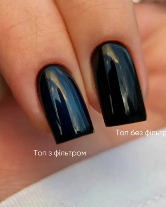 Closeup of black glossy manicure nails, one with and one without top coat filter, for nail art comparison.