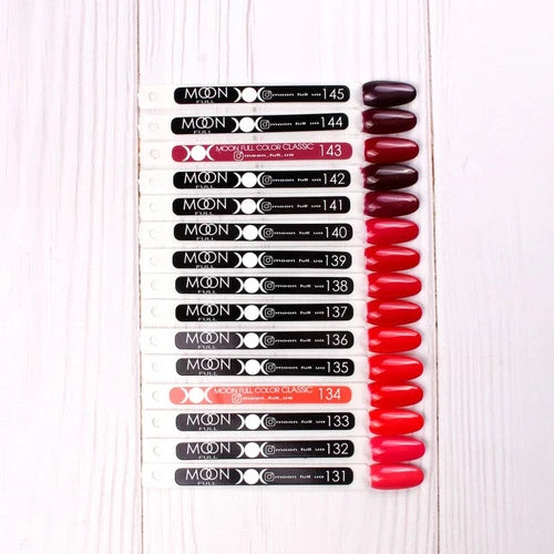 Assorted MOON gel nail polish color swatches in berry, red, and pink shades on display sticks