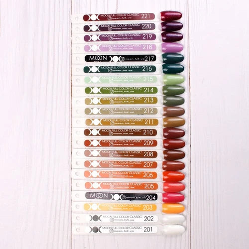 Assorted gel polish color swatches arranged on white wood background, nail sample palette