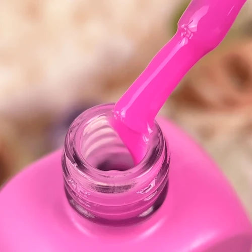 Close-up of a pink gel nail polish bottle with brush for manicure and nail art