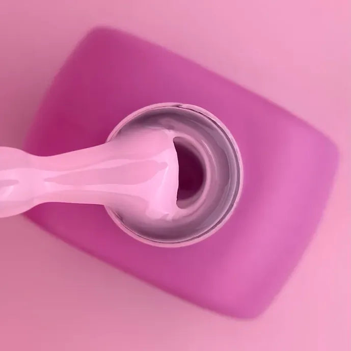 Pink acrylic gel being dispensed from a bottle, ideal for manicure nail extensions