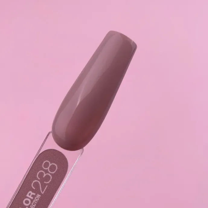 Swatch of mauve-brown gel nail polish on a nail tip with pink background