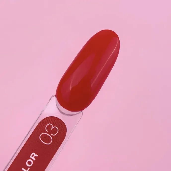 Red gel nail polish swatch on stick labeled 03 against pink background
