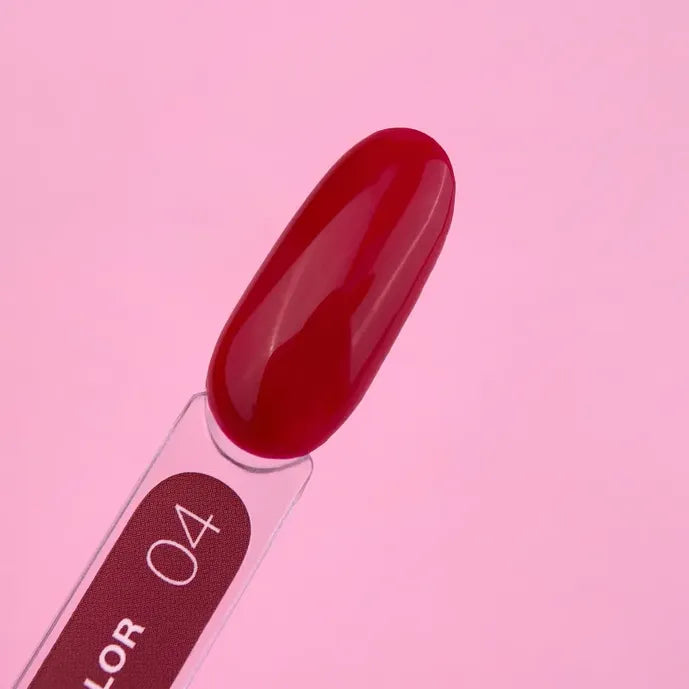 Glossy red gel nail polish swatch on color sample stick, pink background, shade 04
