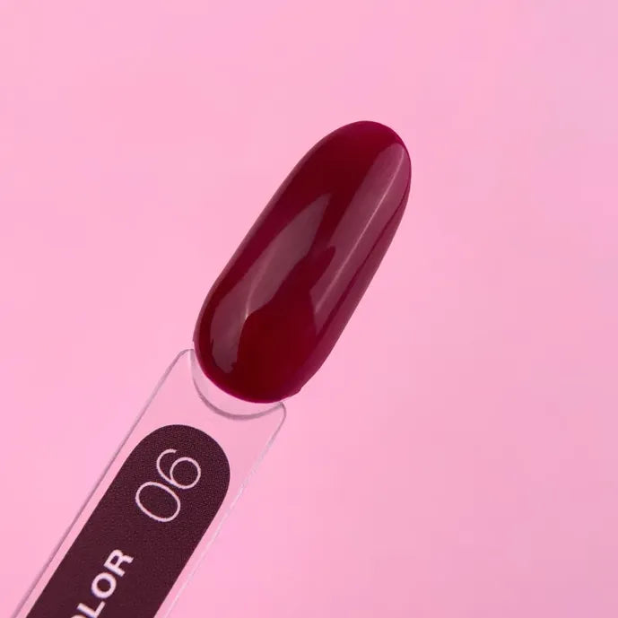 Dark red gel nail polish swatch on clear stick, labeled 06, against pink background