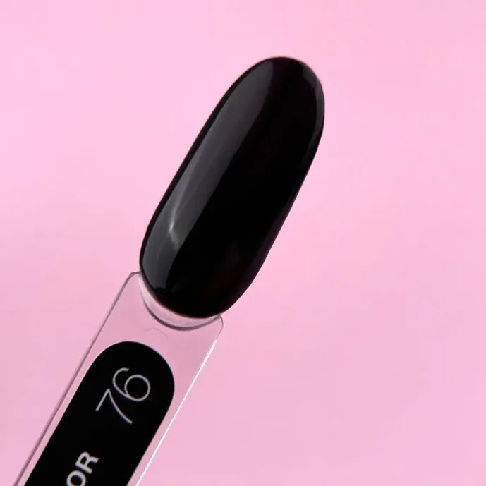 Black gel nail polish color swatch on a clear stick, pink background